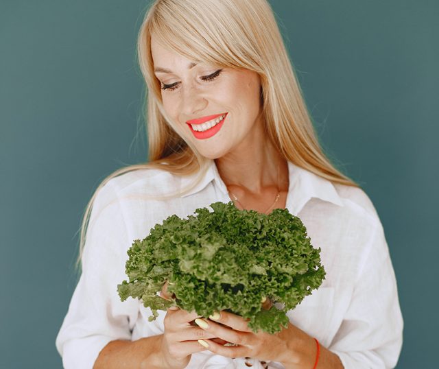 Beautiful and sporty girl in a kitchen with a vegetables